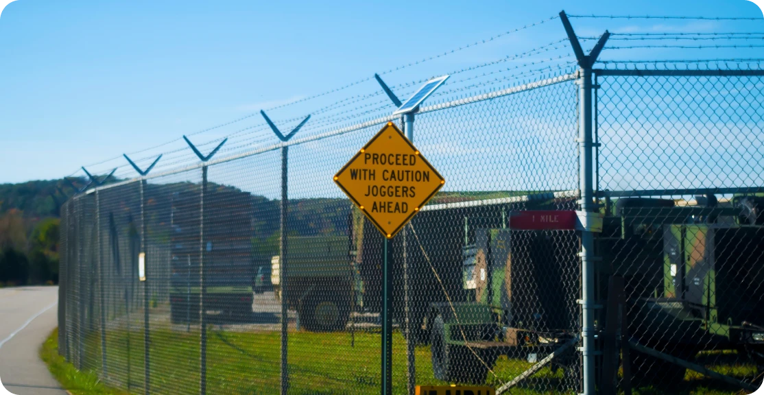 Warning sign by barbed wire fence
